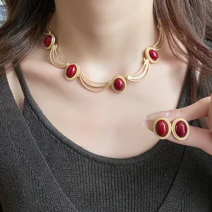 Vintage royal style choker and earrings set featuring red oval gems on model wearing top