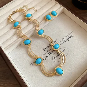 Detailed close-up of vintage gold necklace and earrings set with turquoise oval stones