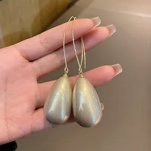 Elegant French style champagne gold teardrop pearl earrings featuring long minimalist hooks