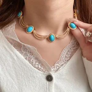 Detail of vintage palace style gold necklace featuring oval turquoise blue stones