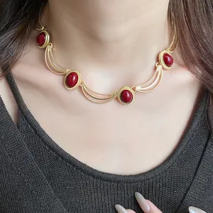 Detailed view of a vintage oval red gemstone necklace in an elegant gold-toned court style