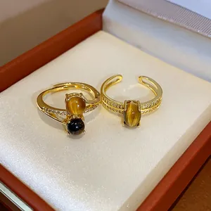 Detailed macro shot of 18k gold plated open rings featuring tiger eye stones and zircon.