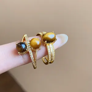 Detail of 18k gold plated rings featuring natural tiger eye stones and zircons