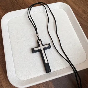 Collana con pendente a croce vintage nera e argento su sottile cordino in pelle di nicchia