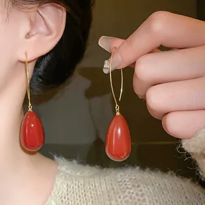Detailed view of vintage French style red waterdrop earrings with elegant gold hooks