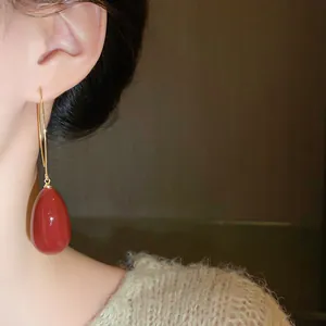 Elegant vintage red teardrop ear hook earring close-up view worn on a model's ear