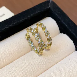 Nahaufnahme von 14k vergoldeten Creolen mit bunten Zirkonia-Steinen in einer Box