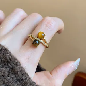 Detail of 18k gold plated ring featuring two tiger eye stones and zircons