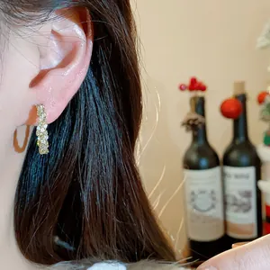 Elegante Nahaufnahme von 14k vergoldeten Zirkonia-Creolen an einem asiatischen Model.
