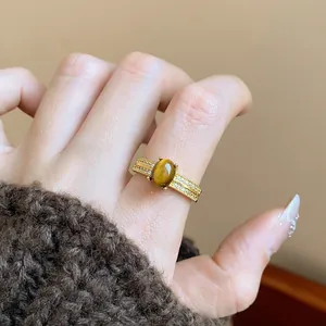 Close-up detail of a vintage 18k gold plated ring with a central Tiger's Eye gemstone.