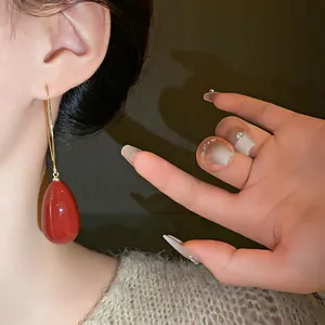 Detailed macro view of French vintage red waterdrop earrings with elegant gold ear hooks