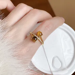 Macro detail of 18k gold plated ring featuring dual tiger eye stones and zircon