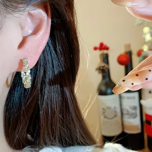 Nahaufnahme von minimalistischen 14k vergoldeten Creolen mit Zirkonia am Ohr.