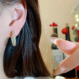 Detailansicht eines mit 14k Echtgold überzogenen Zirkonia-Ohrrings am Ohrläppchen