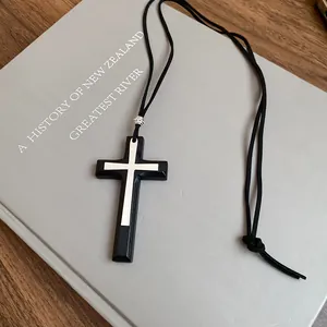 Dettaglio ravvicinato di una collana a croce nera vintage con inserto in argento
