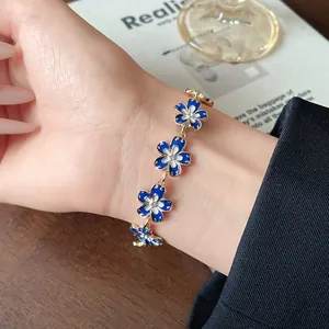 Vista dettagliata di un bracciale a fiori in smalto blu Klein con strass al polso
