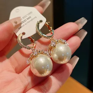 Elegant silver needle hoop earrings featuring large pearls and sparkling crystal accents