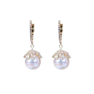 Elegant gold-toned pearl drop earrings with crystal-encrusted hoop and floral cap