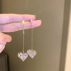 Detailed view of sparkling heart-shaped tassel earrings with shimmering crystal pavé
