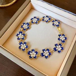 Dettaglio di un bracciale a fiori in smalto blu Klein vintage con strass al centro.