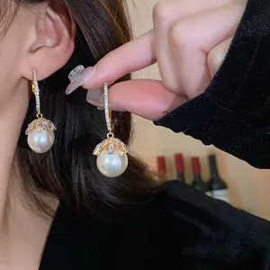 Detailed shot of elegant silver needle pearl earrings with sparkling zircon flower design