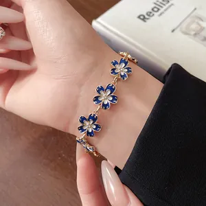 Dettaglio ravvicinato di un bracciale vintage a fiori smaltati blu Klein con strass al polso