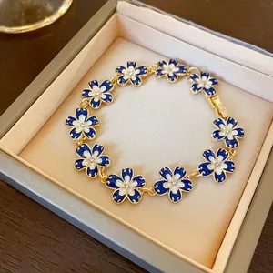 Dettaglio macro del bracciale vintage con fiori in smalto blu Klein e strass