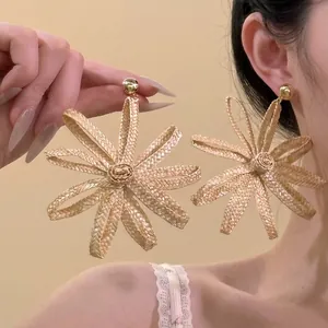 Large woven rattan flower drop earrings for a trendy bohemian vacation style accessory