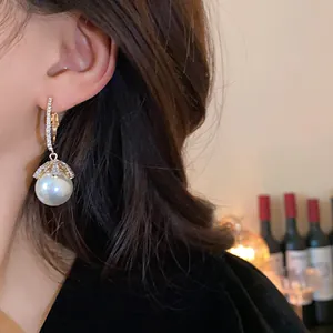 Close-up detail of an elegant pearl drop earring featuring sparkling crystal accents