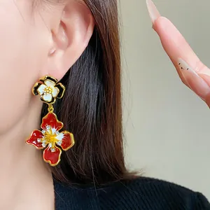 Detailed macro view of vintage red floral enamel earrings with sparkling crystals