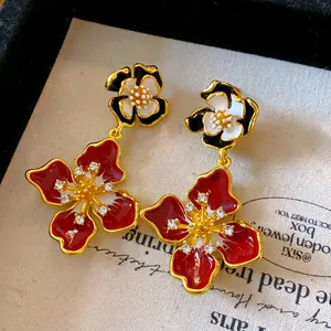Detailed close-up of French vintage enamel flower earrings with sparkling rhinestones