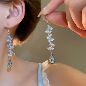 Elegant blue butterfly dangle earrings featuring crystal teardrop and silver needle accents.