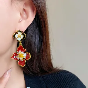 Detail of vintage enamel flower earrings with sparkling crystal accents worn on ear
