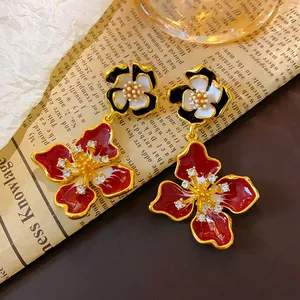 Macro detail of French vintage red and black enamel flower drop earrings with crystals