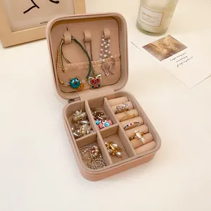 Primer plano de un joyero de cuero portátil con espacio para anillos y collares