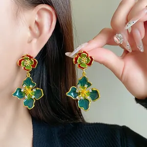 Detailed macro view of vintage French flower earrings with green enamel and crystals