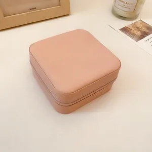 Primer plano de un joyero portátil de cuero rosa con un elegante diseño de cremallera.