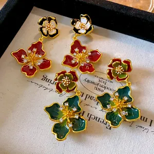 Detailed macro view of French retro enamel flower earrings with sparkling rhinestones.