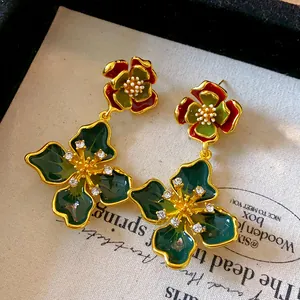 Close-up of vintage French style enamel flower earrings with sparkling rhinestones.