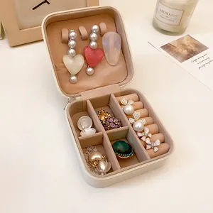 Detalle interior del joyero de cuero portátil con varios compartimentos de almacenaje