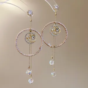 Close-up of rattan woven hoop earrings with sparkling crystals and faceted beads