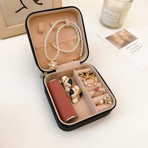 Vista detallada del joyero de cuero portátil con compartimentos para anillos y collares
