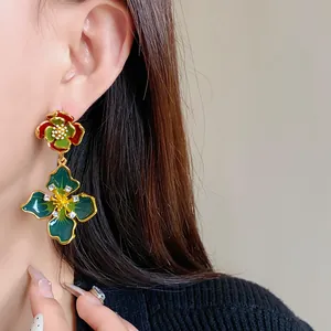 Close-up of retro floral enamel earrings with sparkling rhinestones worn by a model