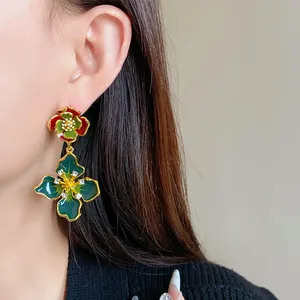 Detailed close-up of vintage enamel flower drop earrings with rhinestones on model