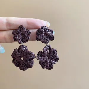 Detail showing the intricate rattan woven texture of these brown flower drop earrings.