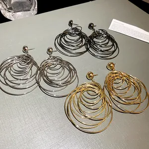 Close-up of layered hoop earrings in gold, silver, and gunmetal metallic finishes