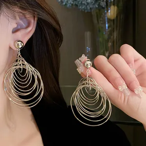 Close-up of stylish multi-layered silver circle hoop earrings with metallic finish