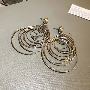 Detail view of multi-layered silver metal hoop earrings with elegant circular design
