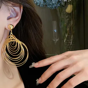 Close-up detail of multi-layered gold circle drop earrings worn by a model