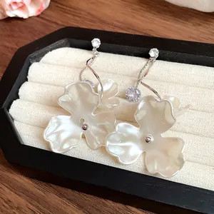 Detailaufnahme von eleganten perlweißen Blumen-Ohrhängern mit funkelndem Zirkonia